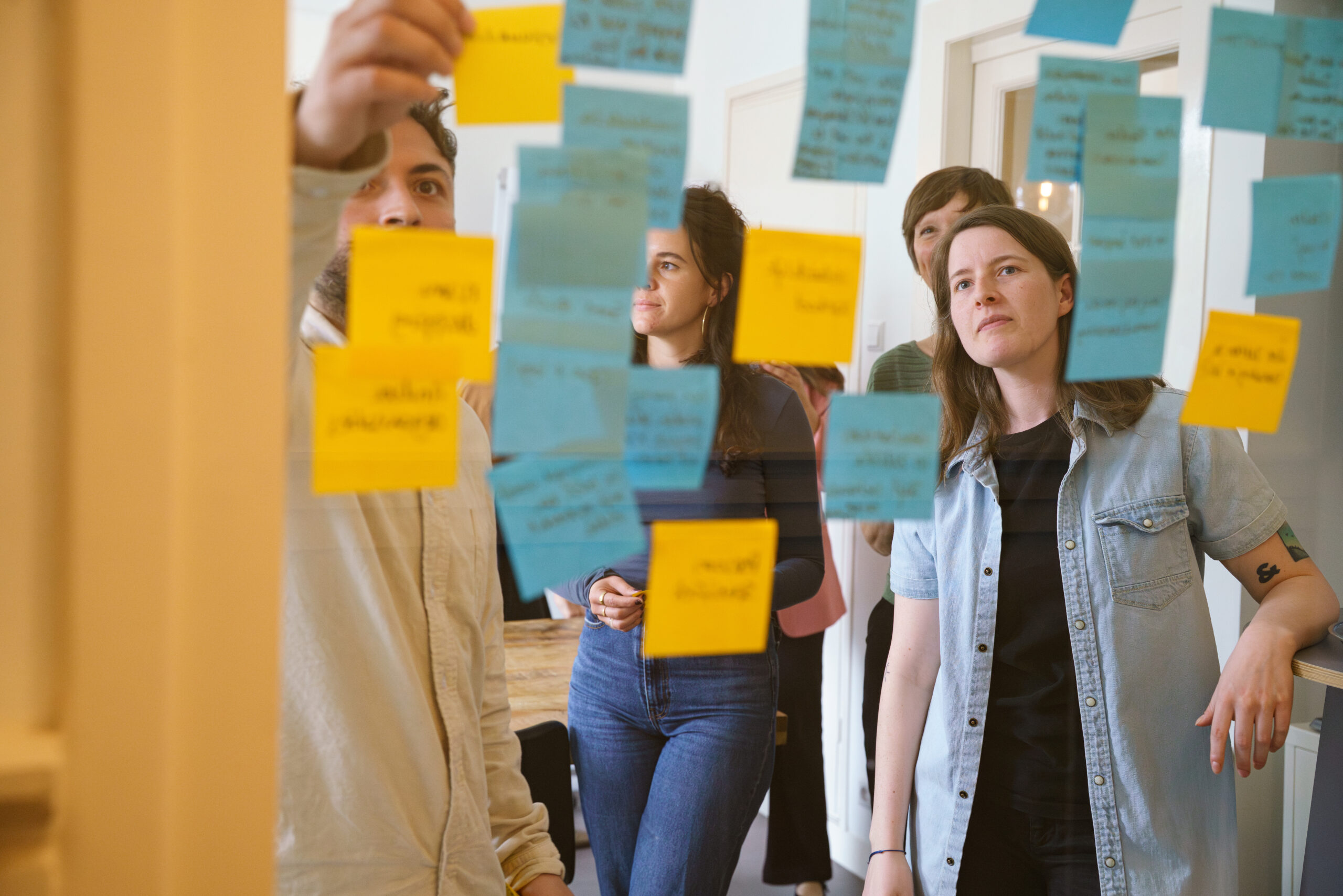 Mensen selecteren en bespreken foto’s op tafel tijdens een creatieve sessie.
