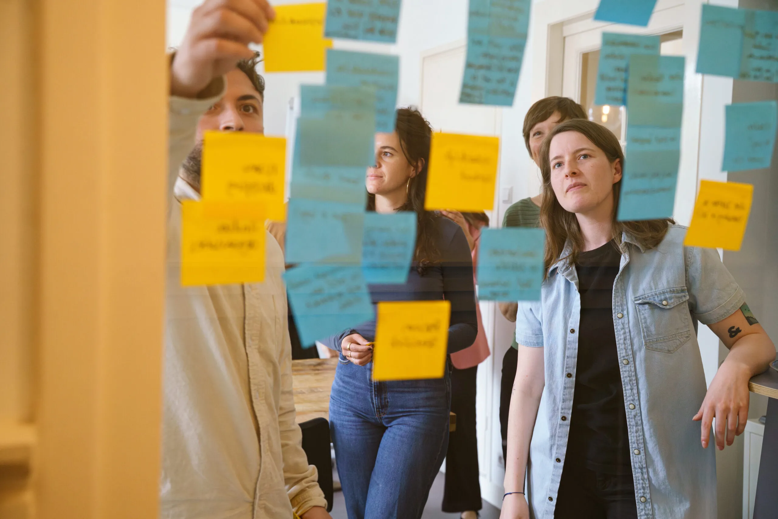 Mensen selecteren en bespreken foto’s op tafel tijdens een creatieve sessie.