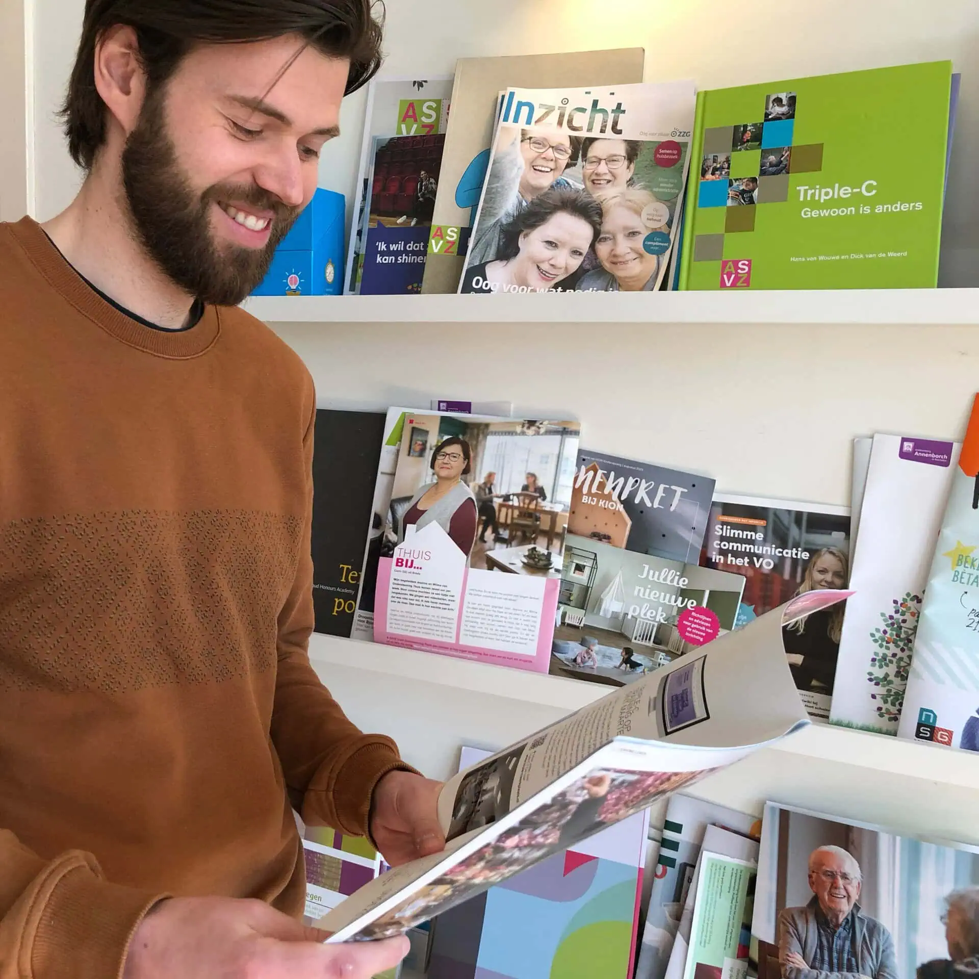 Collega bekijkt een magazine voor een kast vol communicatiemiddelen.